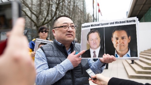 2019年3月6日，在温哥华卑诗省最高法院外，黄先生手持两名被中国关押的加拿大人的照片