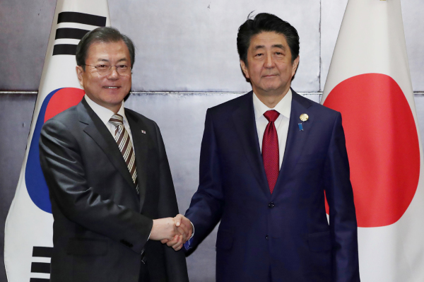 2019年12月24日，韩国总统文在寅与日本首相安倍在四川省成都市举行的会议上握手。