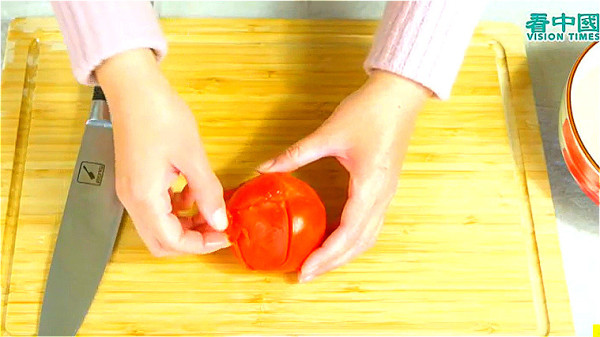 西红柿划十字，用滚水烫15分钟，剥去外皮。
