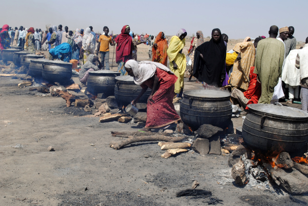2016年2月2日，奈及利亞東北部博爾諾州迪克瓦的一個國內流離失所者營地內，婦女在用木柴加熱的鍋做飯。