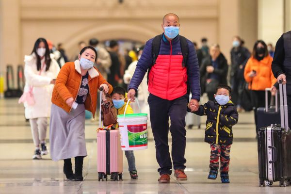 2020年1月21日戴著口罩的通勤者在武漢市的漢口火車站行走