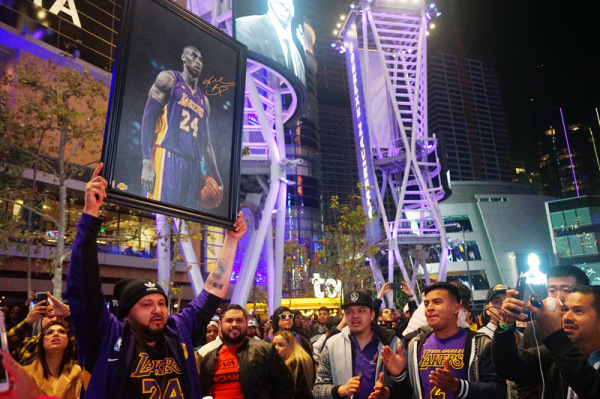 美國職籃NBA洛杉磯湖人傳奇球星布萊恩（Kobe Bryant ）26日不幸墜機過世，大批球迷聚集在湖人主場史泰博中心外廣場，有人高舉布萊恩的照片懷念這位傳奇球星。