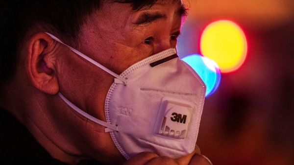 一名带着口罩防范武汉肺炎病毒的中国人