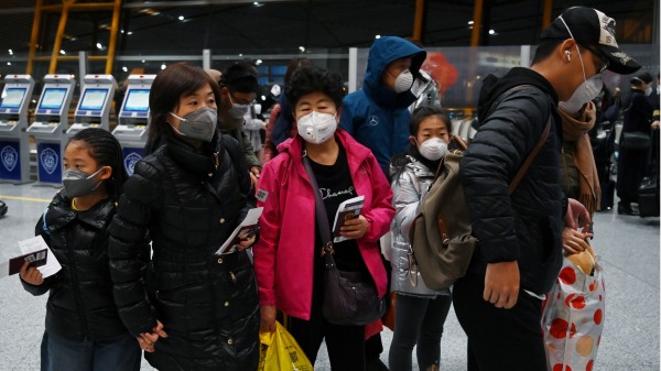 国际航班上戴着防护口罩的乘客在国际机场等待入境