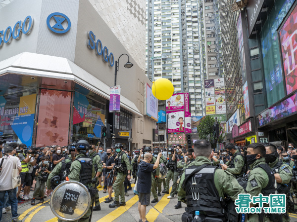 有市民仅举起巨型黄色气球，便遭到大批警察包围并搜身。（图片来源：庞大卫/看中国）