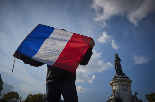 10月18日，一名示威者揮舞著法國三色旗，上面寫著「言論自由」。