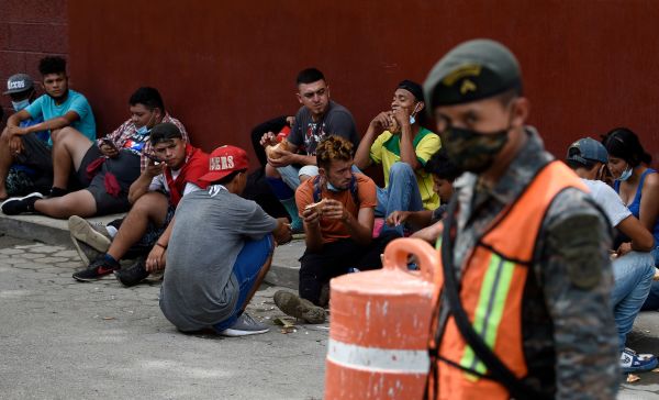 2020年10月3日，瓜地馬拉一個移民避難所外面，士兵守衛著一群宏都拉斯移民。
