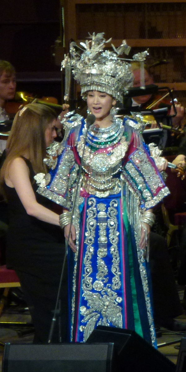 图为宋祖英（Song Zuying）于2012年6月在伦敦皇家阿尔伯特音乐厅举行的东方遇见西方音乐会上以苗族服装演唱龙舟调Dragon Boat Melody。（图片来源：网络）
