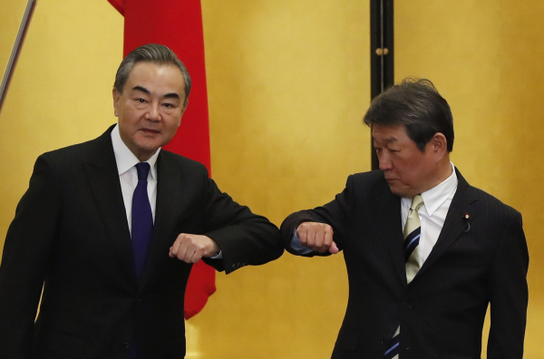 2020年11月24日，中国外长王毅访问日本期间与日本外相茂木敏充碰肘问候。