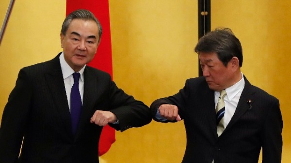 2020年11月24日，中國外長王毅訪問日本期間與日本外相茂木敏充碰肘問候。