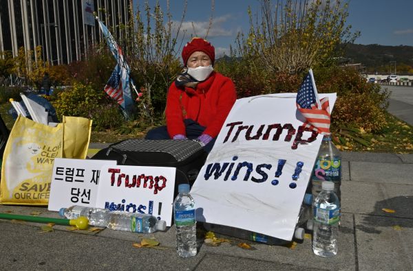 11月3日，韓國首爾，一名女子在大使館面前豎起川普贏的牌子。