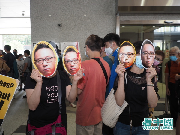 支持者戴上谭得志纸面具。（图片来源：李天正/看中国）