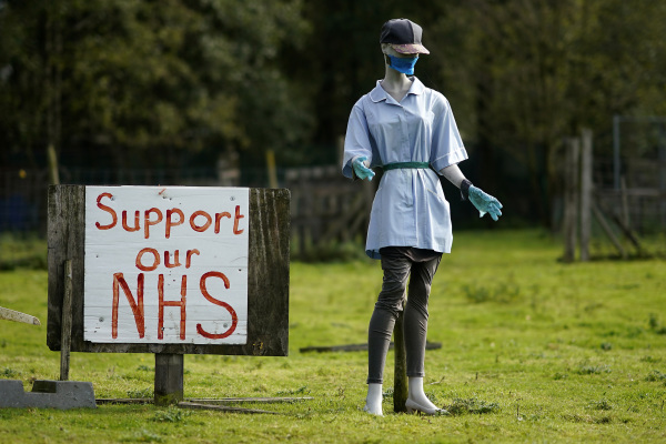 10月06，英國諾斯維奇，一個戴著口罩和護士服的時裝模特站立在支持NHS的標誌旁邊。