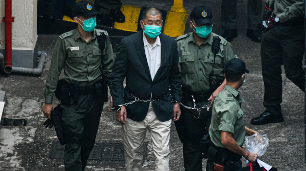 圖為去年12月12日，壹傳媒創辦人黎智英被腰纏鐵鍊押送至法院提堂。（圖片來源：Getty Images）
