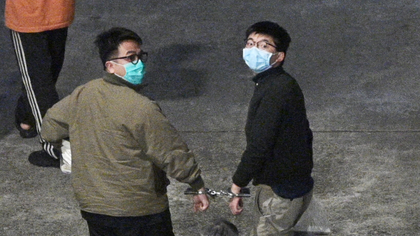 前香港眾志秘書長黃之鋒、前主席林朗彥12月2日被判囚後，被帶返荔枝角收押所，回頭望向傳媒。（圖片來源：ANTHONY WALLACE/AFP via Getty Images）