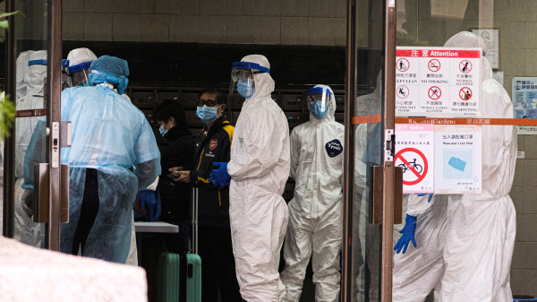 2020年12月10日，检疫人员进入一栋疫厦，其住户则撤离往检疫中心。 （图片来源：Keith Tsuji/Getty Images）