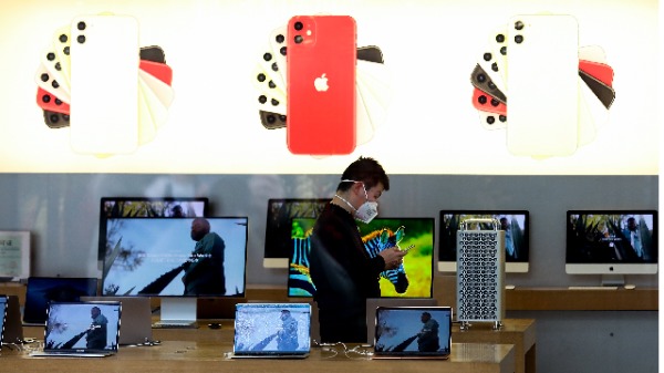 2月17日，北京的苹果商店店员戴着口罩营业（图片来源：Lintao Zhang/Getty Images）