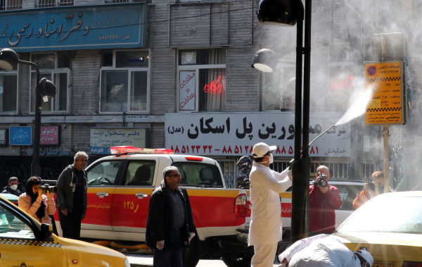 2020年3月5日，伊朗首都德黑兰的防疫人员在一条街道上消毒。
