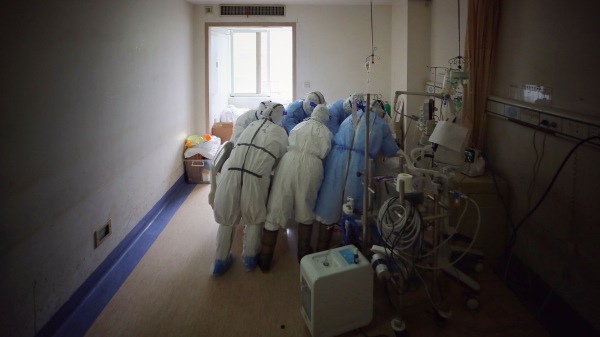 医务人员于2020年3月11日在武汉市的红十字会医院治疗一名感染中共病毒的患者。