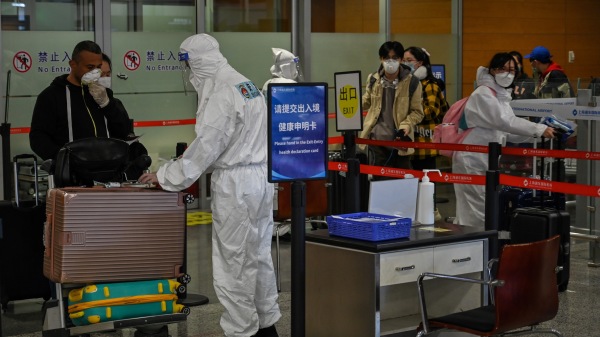 戴著口罩的乘客於2020年3月18日抵達上海浦東國際機場。