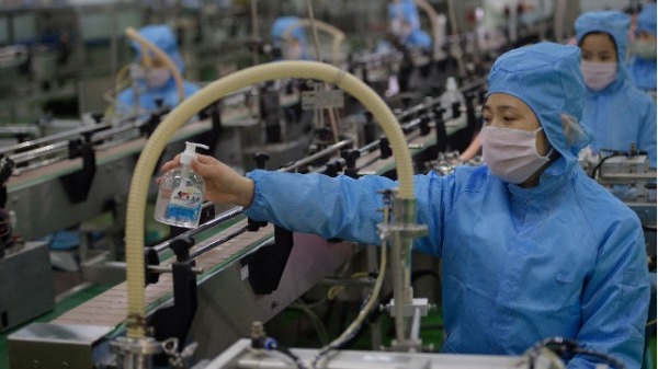 2020年3月19日，朝鲜平壤一家肥皂工厂的生产线上的工人在检查瓶装新的消毒剂产品。