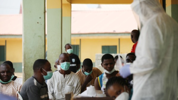 2020年4月15日，非洲的在奈及利亞一個社区，民眾等待着卫生工作人员准备取样，以進行中共病毒檢测