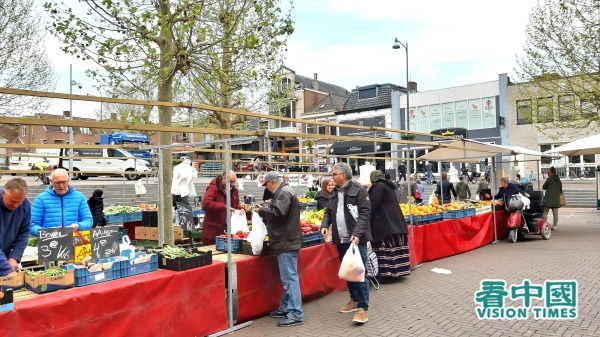 2020年4月18日，荷蘭市民在室外的一個水果蔬菜攤位購物。
