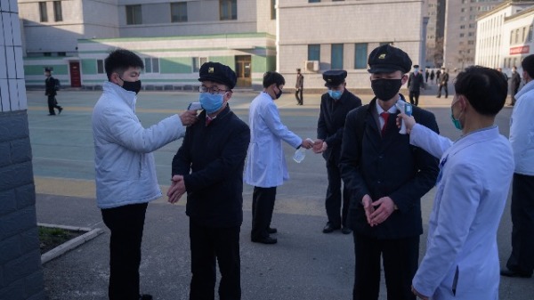 2020年4月22日，朝鲜平壤医科大学的学生在进校门前要进行消毒，并体温检查