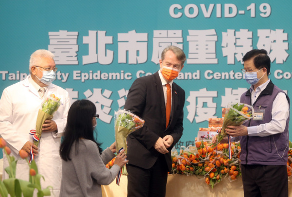 代表纪维德（右2）27日赠送郁金香给予台北市联合医院医护人员，并由台北市卫生局长黄世杰（右）、北市联医总院长黄胜坚（左）等人代表接受。