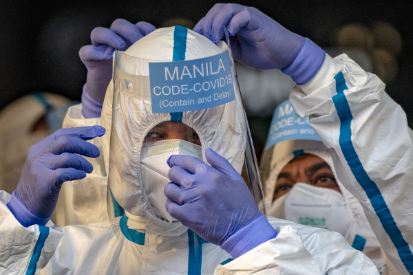 2020年4月15日，菲律賓馬尼拉警察穿著防護服，準備運送可能感染中共病毒的患者。
