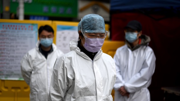 4月4日，武汉市一条街道上，身穿防毒服的社区志愿者默哀三分钟。