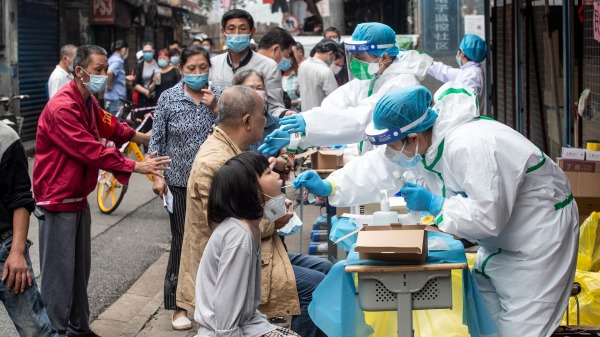 2020年5月15日，武汉市的一条街道上居民们排队等候病毒筛检。