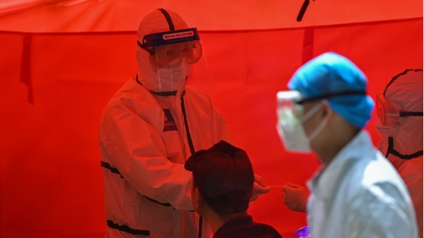 有幾位在武漢肺炎疫情期間製造「正能量」與「暖新聞」的當事人向《寒冬》敘述了他們的親身經歷。圖為2020年5月19日，一名醫務人員準備在武漢市給一名男子檢查。