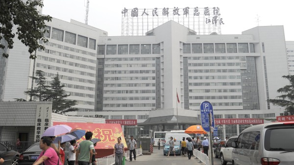 2011年7月6日，一名妇女（L）骑自行车经过北京301医院。