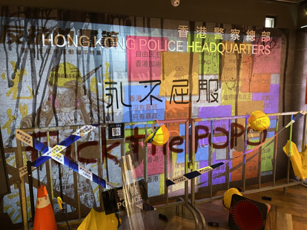 「反抗的畫筆–香港反送中運動週年圖像展」的現場裝置藝術設計，是以數位連儂牆疊影在香港警察總部的場景。