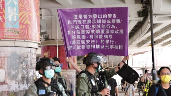 “港区国安法”已生效，港警7月1日针对自行上街“七一”游行的群众，第一次举出了象征执行此法的紫色旗帜。