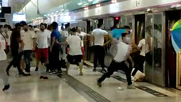 去年7月21日，大批白衣人持棍棒等在元朗站月台甚至车厢殴打市民。（图片来源：立场新闻/视频截图）