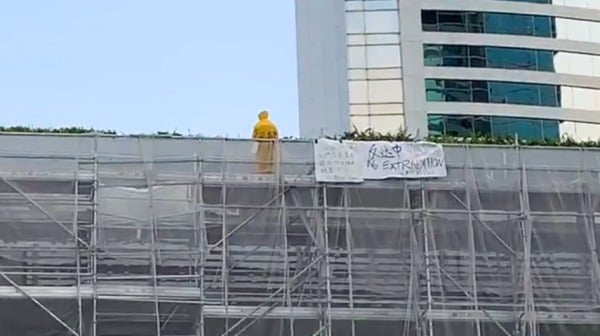 2019年6月15日，梁凌杰穿着背上写有“林郑杀港 黑警冷血”的黄色雨衣，在金钟太古广场的临时工作平台上示威。（图片来源：视频截图）