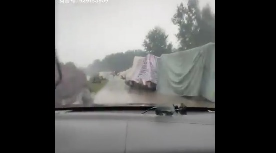 安徽某河堤排满了灾民们自己用塑料布、编织材料搭建的简易帐篷
