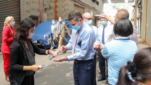 美国卫生部长艾萨率团于12日上午参访“口罩国家队”长宏机械公司时，在进厂房前，访问团成员陆续接受额温检测及手部消毒等防疫措施。