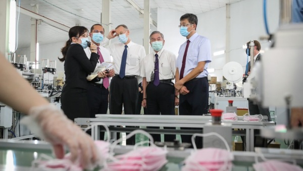 美国卫生部长艾萨（左2）12日上午在行政院副院长沈荣津（左4），以及美国在台协会（AIT）处长郦英杰（左3）等人的陪同下，参访“口罩国家队”的长宏机械公司。