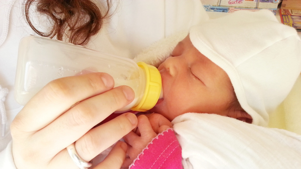 母親以奶瓶為嬰兒餵奶。（圖片來源：Pixabay）