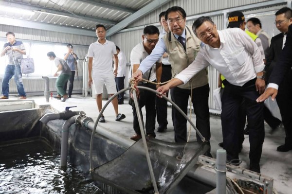 4日，台盐绿能、渔民合作在台南市北门区建立的“智慧渔电共生温室大棚及养殖数位分身示范基地”揭牌，董事长陈启昱（前右）及台南市长黄伟哲（前右2）出席。
