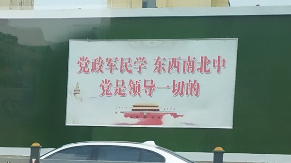 位于山东烟台的宣传标语牌，上面写着“党政军民学 东西南北中 党是领导一切的”。