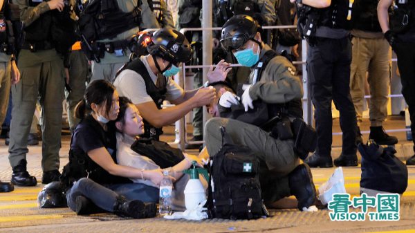 今年8月31日，大批港人在太子港鐵站一帶聚集，港警驅散期間曾箍頸拉跌一名孕婦，她倒地後痛苦流淚，被送院治療。（圖片來源：龐大衛/看中國）
