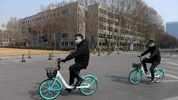 2020年2月28日，两名男子在北京清华大学校园里骑自行车。