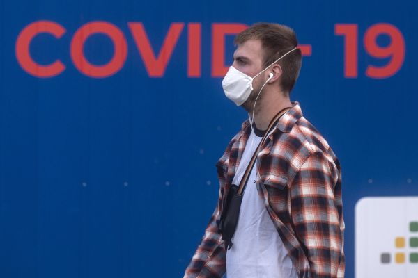 2020年9月24日，捷克布拉格一名戴著口罩男子走過病毒測試站。