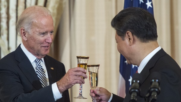 美国副国务卿乔・拜登和中国国家主席习近平在午餐会敬酒 （图片来源：should read PAUL J. RICHARDS/AFP via Getty Images)