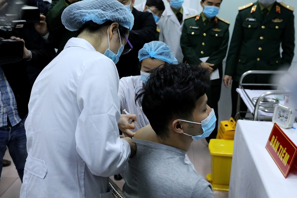 越南軍方醫療人員在向志願者注射越南製藥公司Nanogen開發的Covid-19疫苗。