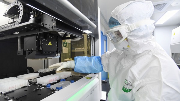 华大基因在武汉实验室人员在处理COVID-19检测样本